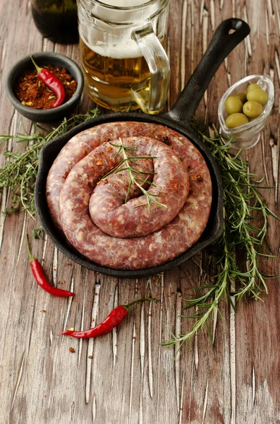 Salsichas de carne crua em uma panela de ferro fundido, foco seletivo — Fotografia de Stock