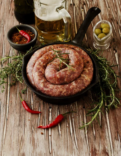 Salsichas de carne crua em uma panela de ferro fundido, foco seletivo — Fotografia de Stock