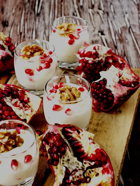 Yogurt dessert with walnuts and pomegranate selective focus — Stock Photo, Image