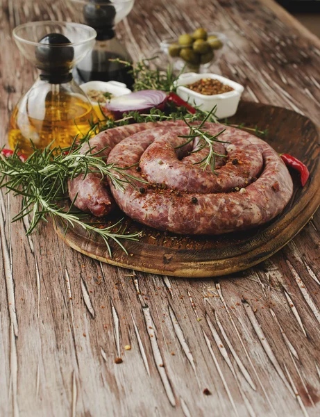 Salsichas de carne crua em uma panela de ferro fundido, foco seletivo — Fotografia de Stock
