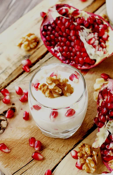 Йогуртовий десерт з волоськими горіхами та гранатовим селективним фокусом — стокове фото