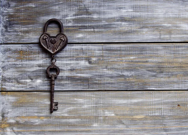 Herz und Schlüssel auf Holzgrund — Stockfoto