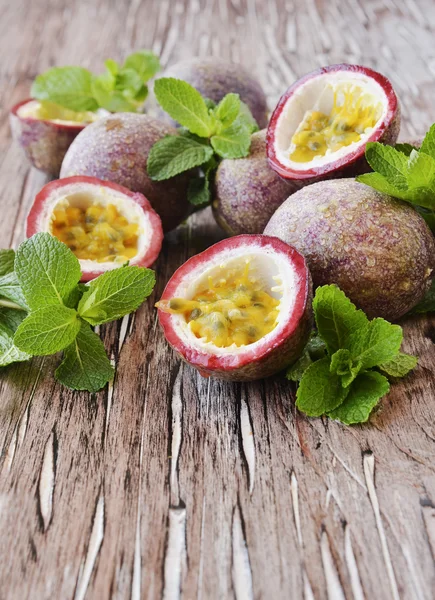 Saftige Fruchtgranadilla mit Minze auf einem Holztisch — Stockfoto