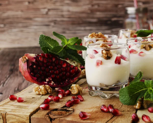 Йогуртовий десерт з волоськими горіхами та гранатовим селективним фокусом — стокове фото