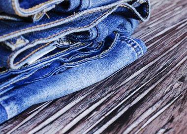 Tahta bir masanın üzerinde yatan kot yığını