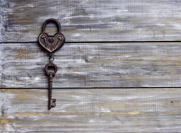 Herz und Schlüssel auf Holzgrund — Stockfoto