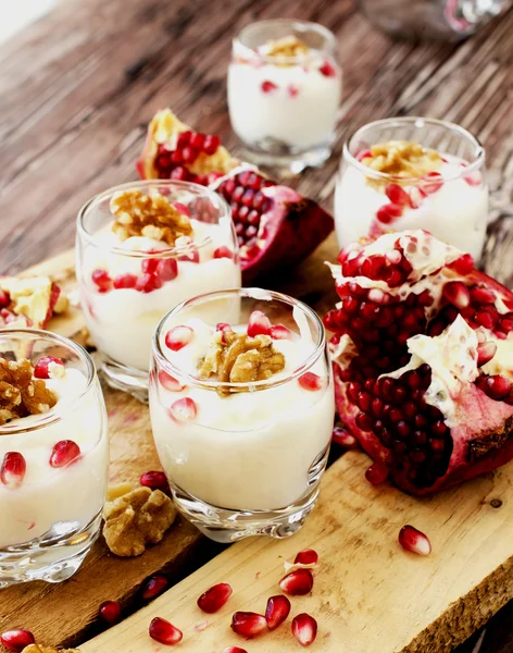 Yogurt dessert with walnuts and pomegranate selective focus — Stock Photo, Image