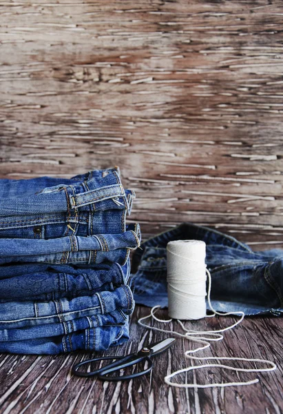 Stapel Jeans auf einem Holztisch liegend — Stockfoto