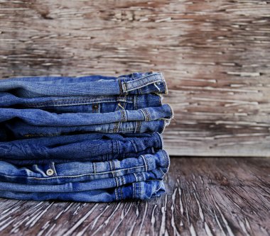 Tahta bir masanın üzerinde yatan kot yığını