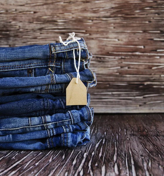 Stapel Jeans auf einem Holztisch liegend — Stockfoto