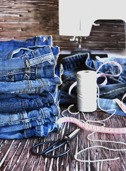 Stapel Jeans auf einem Holztisch liegend — Stockfoto