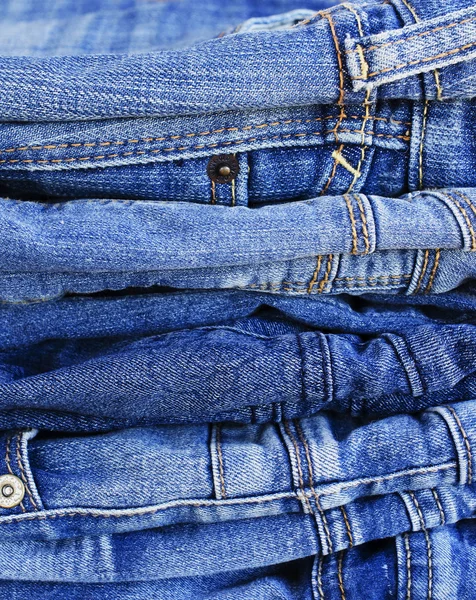 Tahta bir masanın üzerinde yatan kot yığını