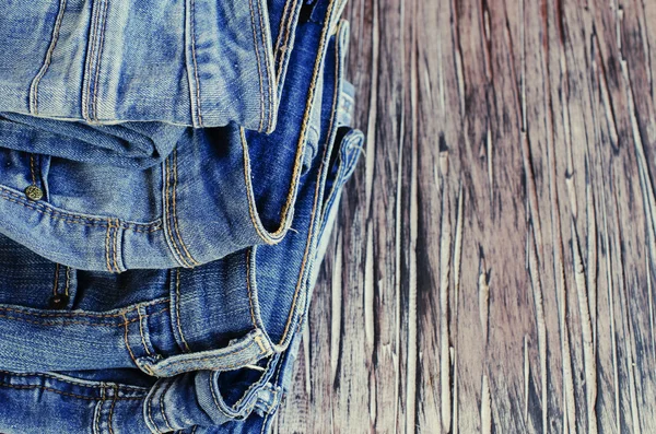 Stapel van jeans liggend op een houten tafel — Stockfoto