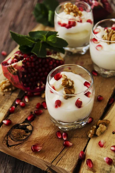 Yoghurt dessert med valnötter och granatäpple selektiv inriktning — Stockfoto