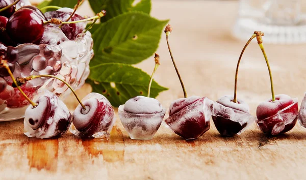 Ripe cherries,ice cubes on wooden table, selective focus — Stock Photo, Image