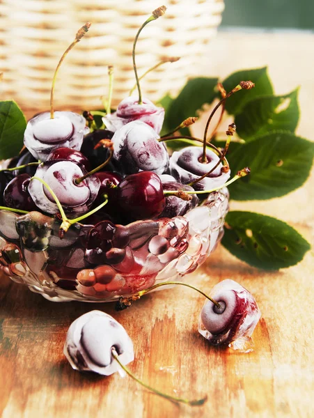 Cerezas maduras, cubitos de hielo en mesa de madera, enfoque selectivo — Foto de Stock