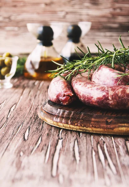 Embutidos de carne cruda en una sartén de hierro fundido, enfoque selectivo —  Fotos de Stock