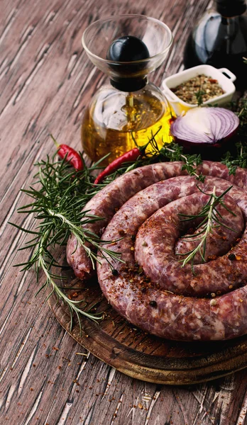 Salsichas de carne crua em uma panela de ferro fundido, foco seletivo — Fotografia de Stock