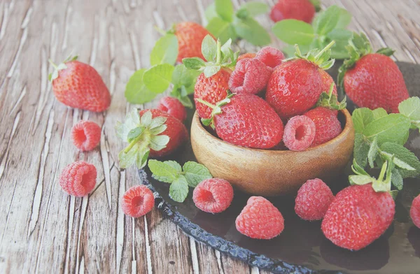 Reife rote Himbeeren und Erdbeeren in Holzschale, selektiver Fokus — Stockfoto