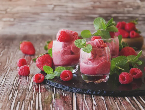 Yogur congelado, sorbete con fresas, frambuesas y menta, enfoque selectivo —  Fotos de Stock
