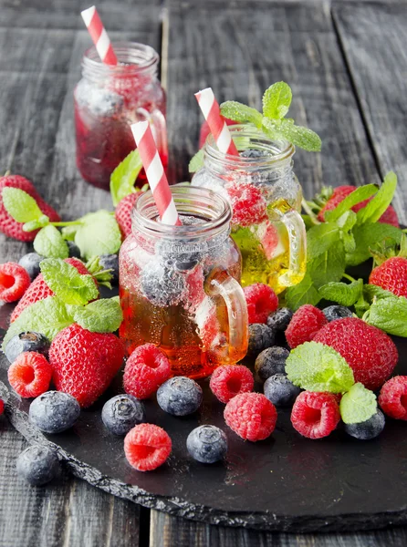 Ягідний сік у склянці з ягодами, льодом та м'ятою — стокове фото