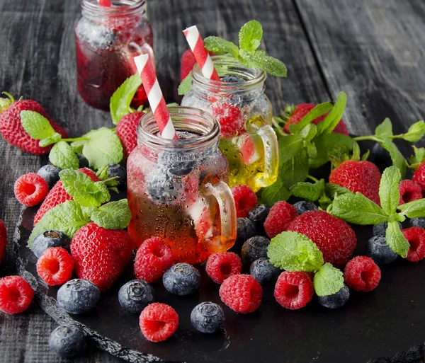 Succo di bacca in un bicchiere con bacche, ghiaccio e menta — Foto Stock