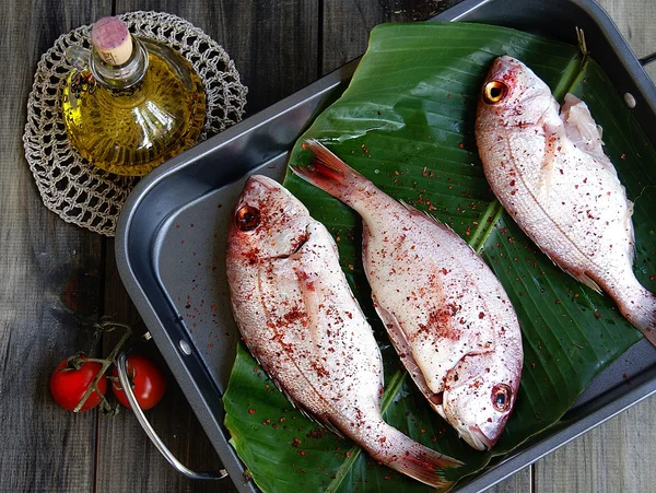 Pescado fresco con verduras en tablas de madera — Foto de Stock