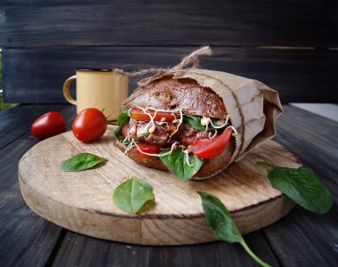 Hamburger siyah ekmek ve masada domates ile