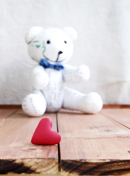 Coração e ursinho em uma superfície de madeira — Fotografia de Stock