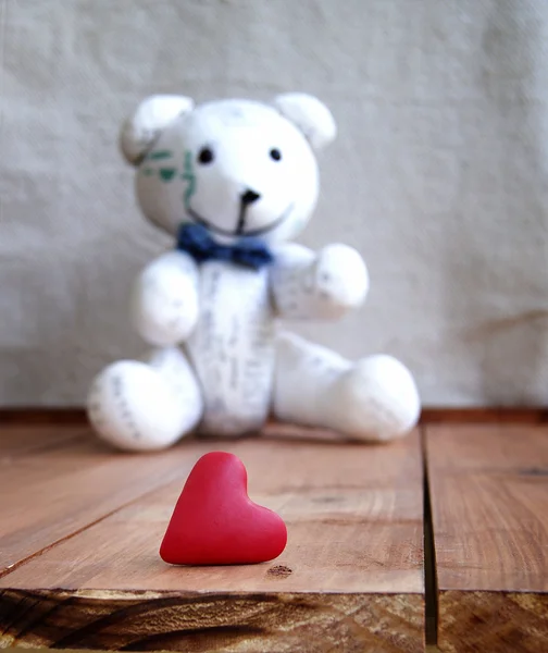 Corazón y oso de peluche sobre una superficie de madera — Foto de Stock