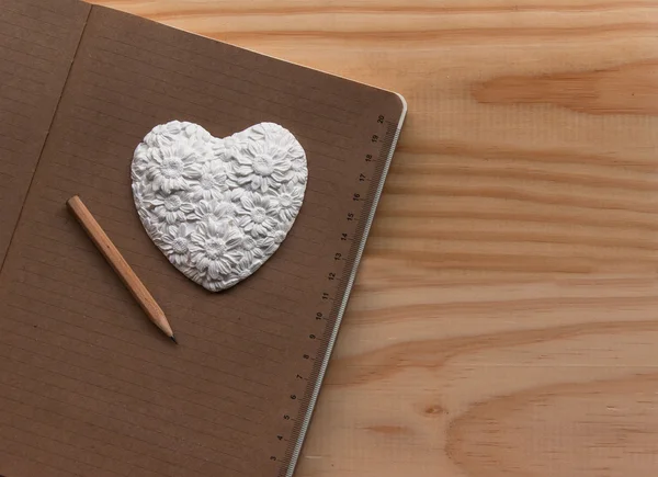 White heart lying on the notebook — Stock Photo, Image