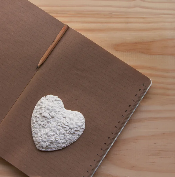 Coração branco deitado no caderno — Fotografia de Stock
