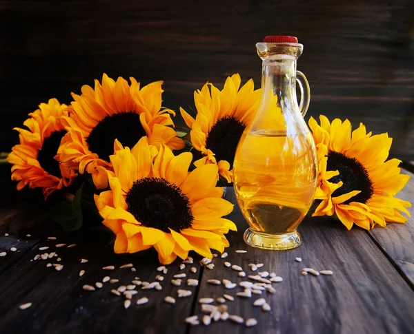 Girasoli, semi di girasole e una bottiglia di olio — Foto Stock