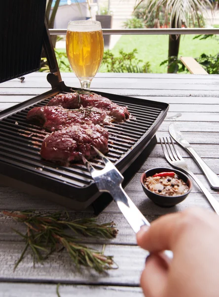 Raw beef with spices, pepper and garlic fried on an electric grill — Stock Photo, Image