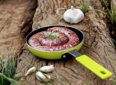 bir tavada sarımsak ile ham sığır sosis