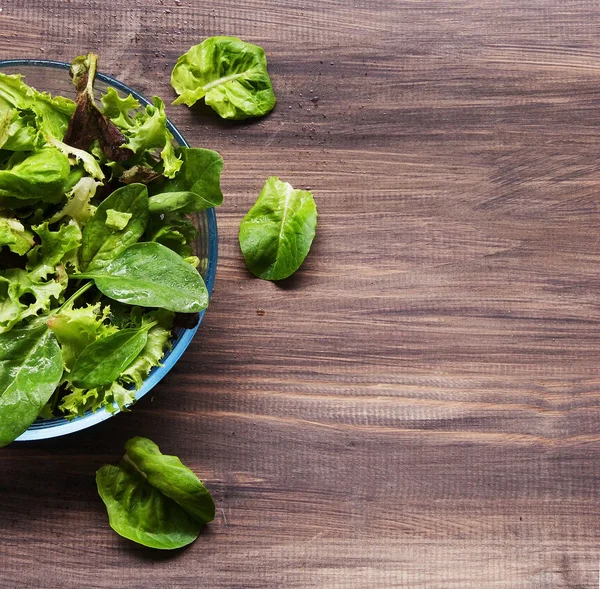 Pan with a green salad on wooden boards — Stock Photo, Image