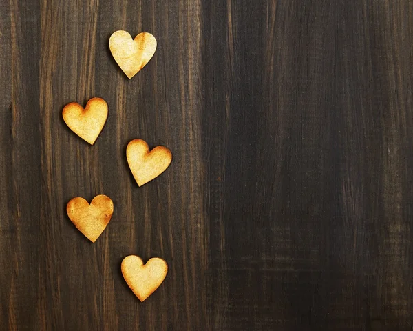 Corazones de madera en una pizarra negra — Foto de Stock