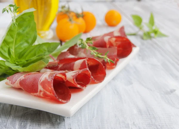 Fresh beef cuts, carpaccio, with vegetables and basil — Stock Photo, Image