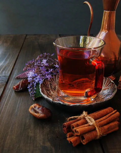 Xícara de chá, canela, anis, bule de chá e flores — Fotografia de Stock