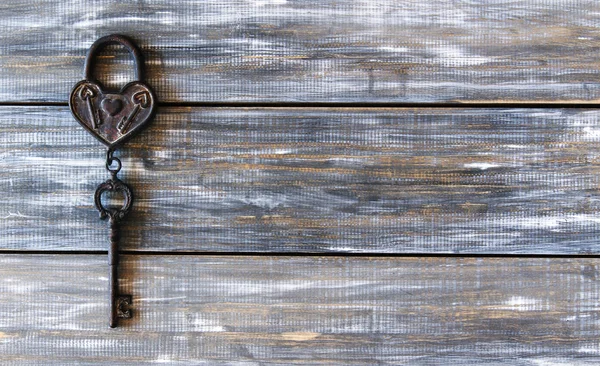 Srdce a klíč na dřevěné pozadí — Stock fotografie