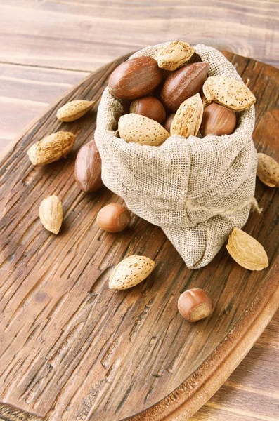 Canvas bag with nuts on a wooden table — Stock Photo, Image