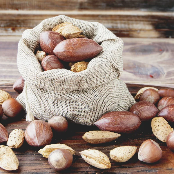 Canvas bag with nuts on a wooden table — Stock Photo, Image