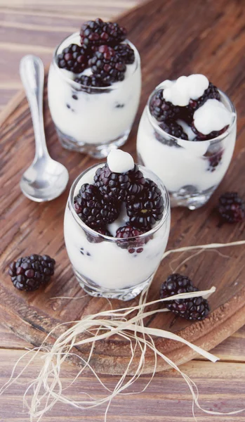 Joghurtos kupa a blackberry a fából készült asztal — Stock Fotó