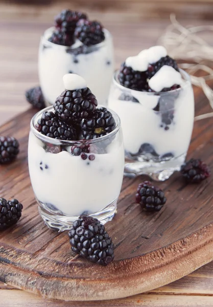 yogurt cup with blackberry on wooden table