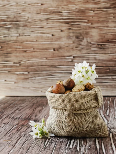 Płócienną torbę z orzechów na drewnianym stołem — Zdjęcie stockowe