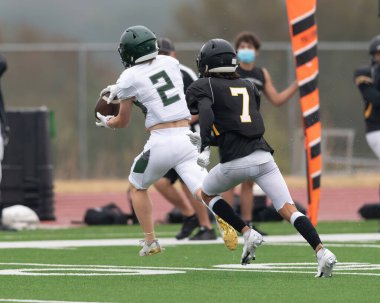 İnanılmaz sporcular, rekabetçi bir futbol maçında harika yakalayıp koşuyor.