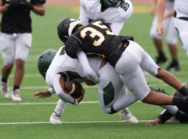 İnanılmaz sporcular, rekabetçi bir futbol maçında harika yakalayıp koşuyor.