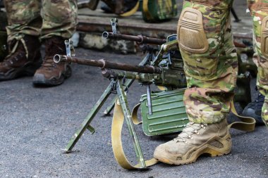 Eğitim sırasında askeriyenin yanında bir makineli tüfek duruyordu.