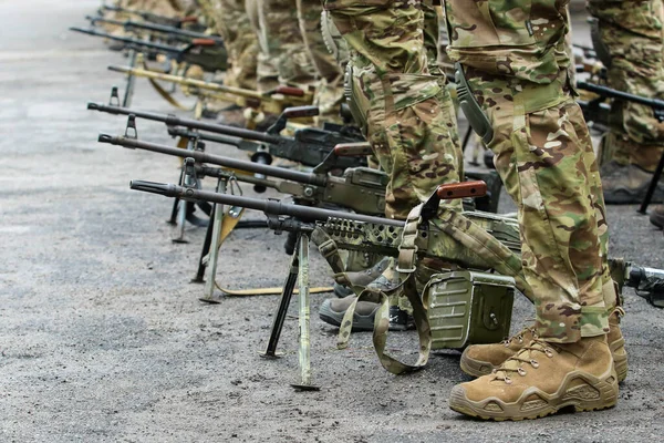 Machine guns stand on the ground near the military during exercises