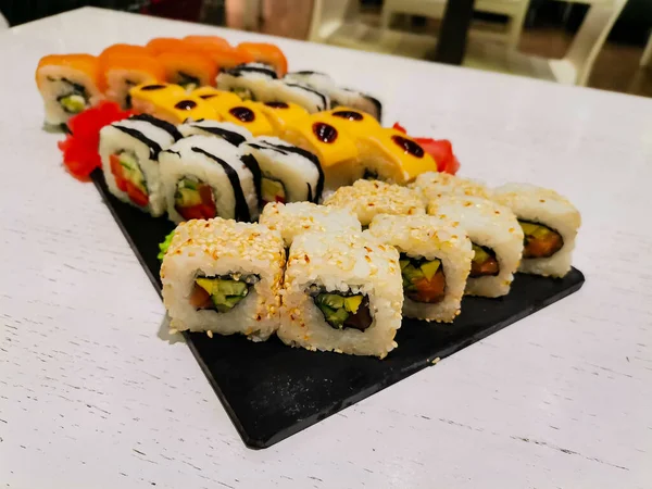 Set Sushi Con Salmón Pepinos Salsas Queso Sobre Una Pizarra — Foto de Stock